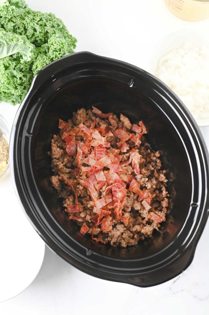 cooked and crumbled sausage and bacon in a slow cooker