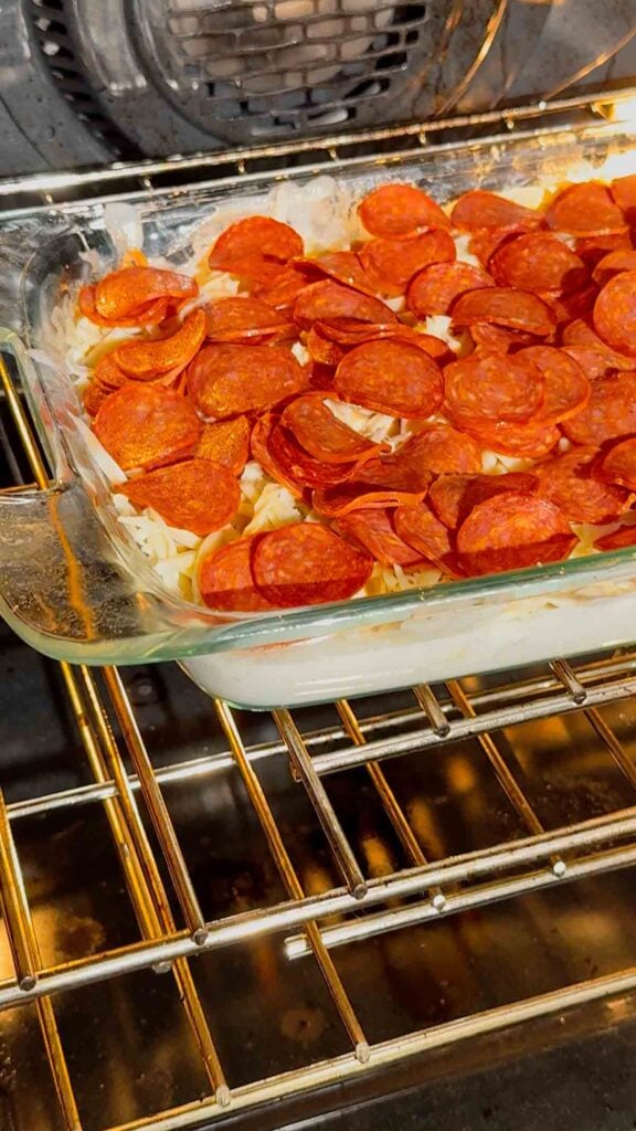 pepperoni tortellini alfredo in a baking dish in the oven