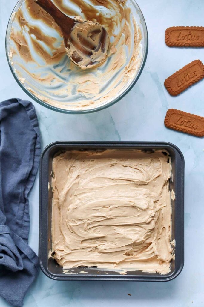 cheesecake mixture spread over crust in a baking pan