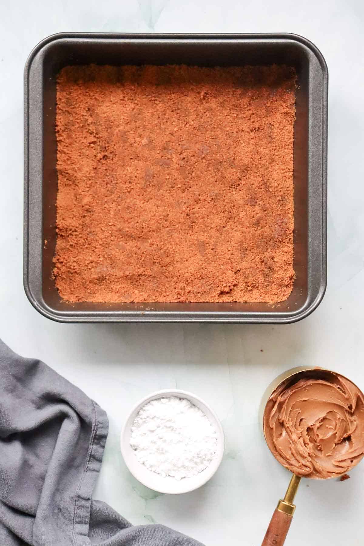 biscoff cookie crust pressed into a baking pan