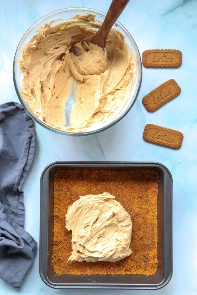 no bake cheesecake mixture scooped on to Biscoff cookie crust in a baking pan