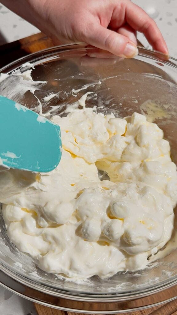 stirring melting marshmallows in a glass bowl