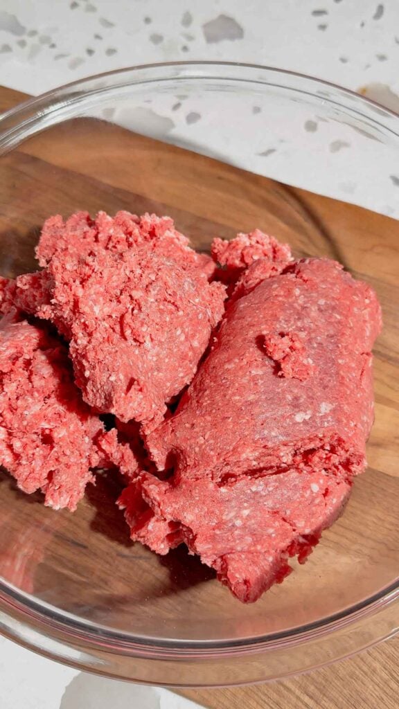 raw ground beef in a glass mixing bowl