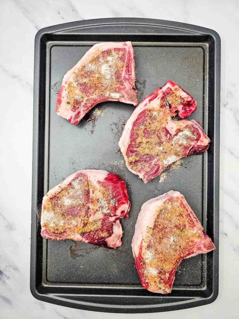 seasoned pork chops on a sheet pan