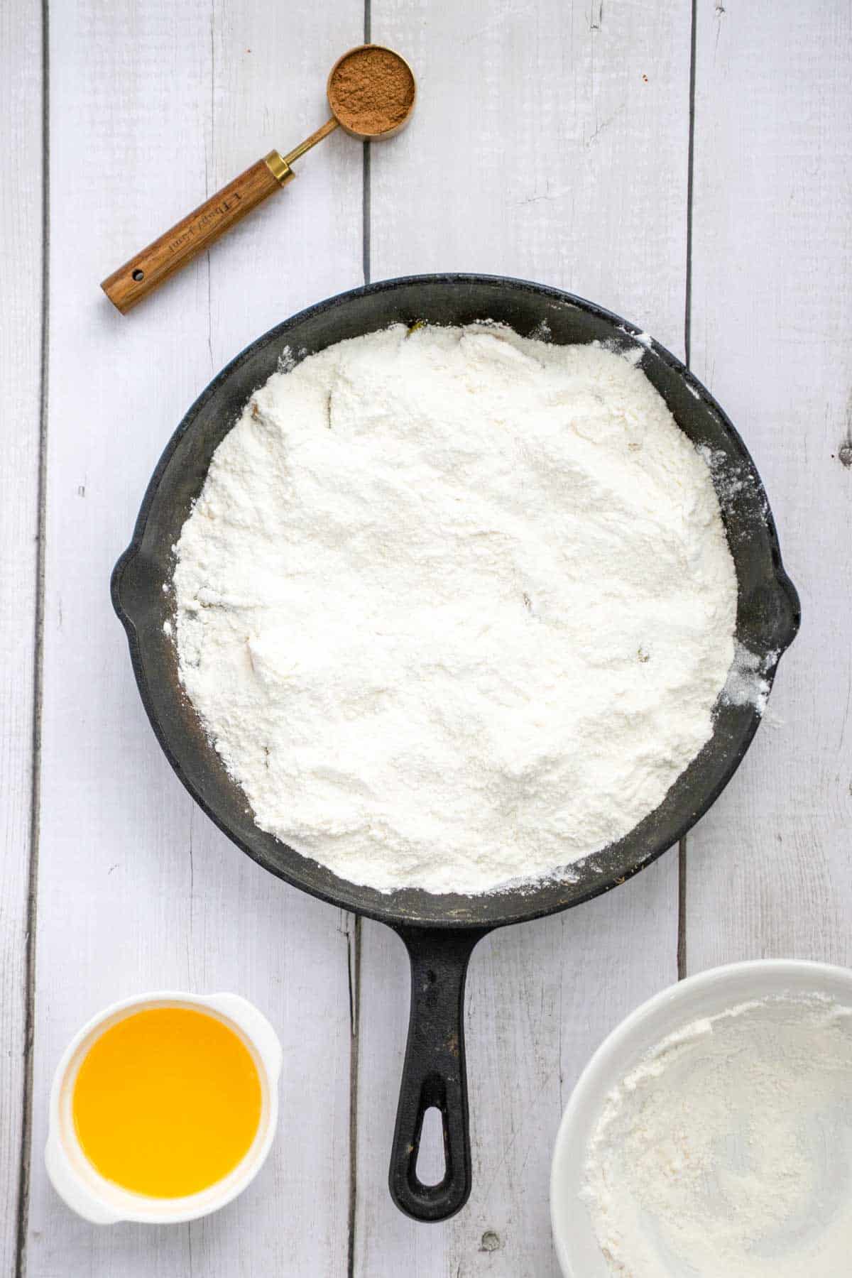 boxed cake mix poured evenly over the peaches in the skillet