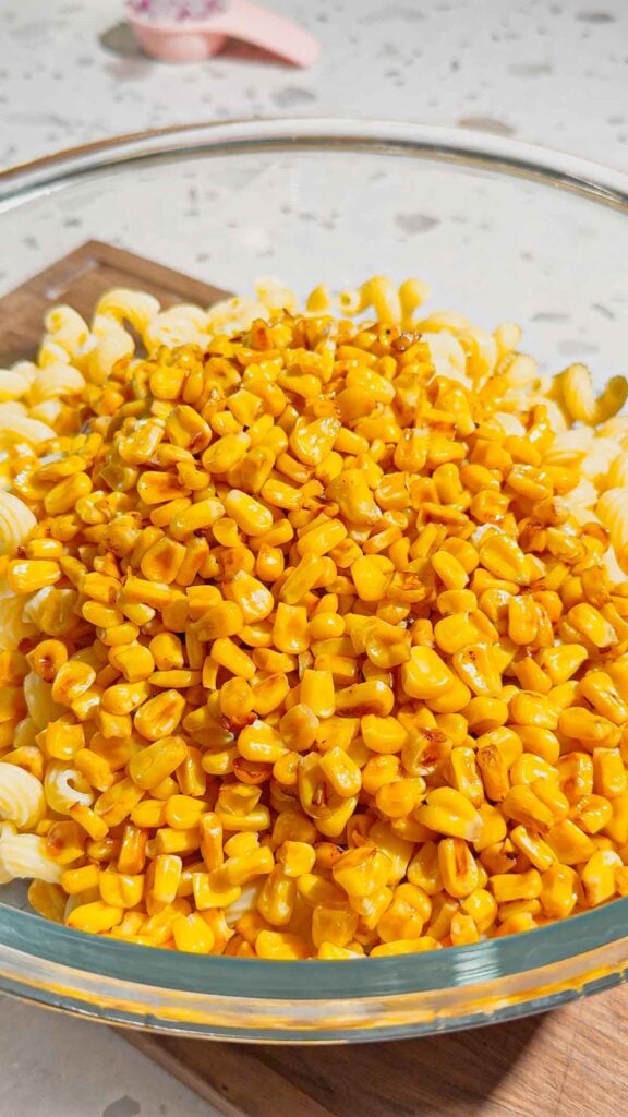 cooked corn and pasta in a glass mixing bowl