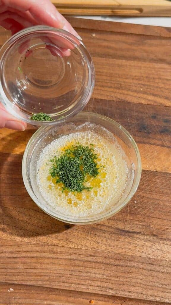 chopped parsley added to bowl with melted butter and garlic powder