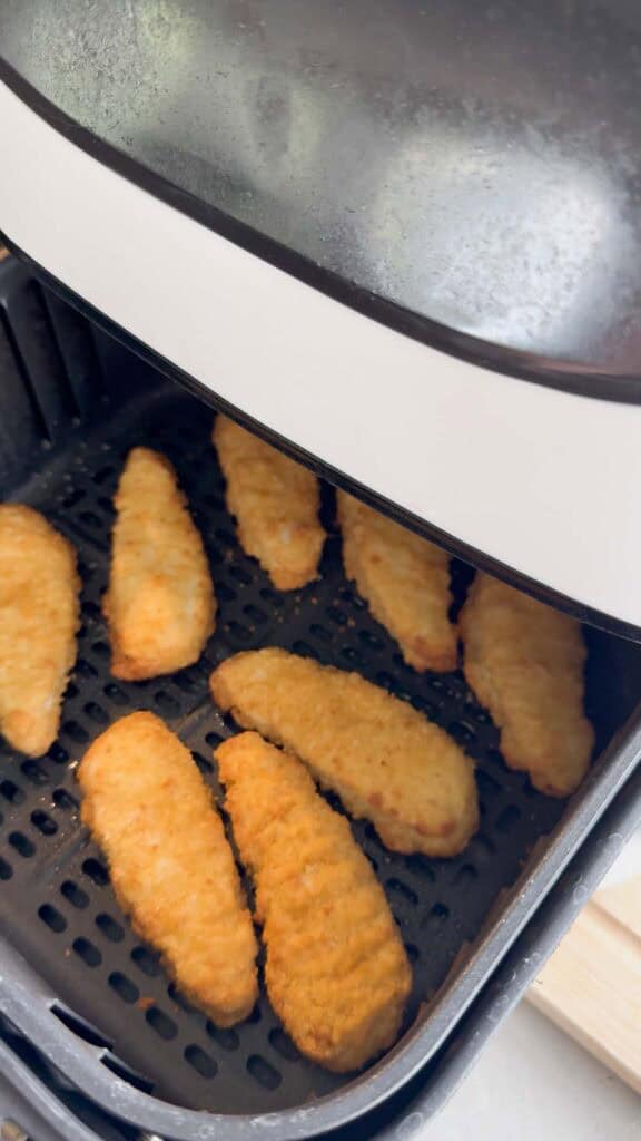 chicken fingers in an air fryer basket
