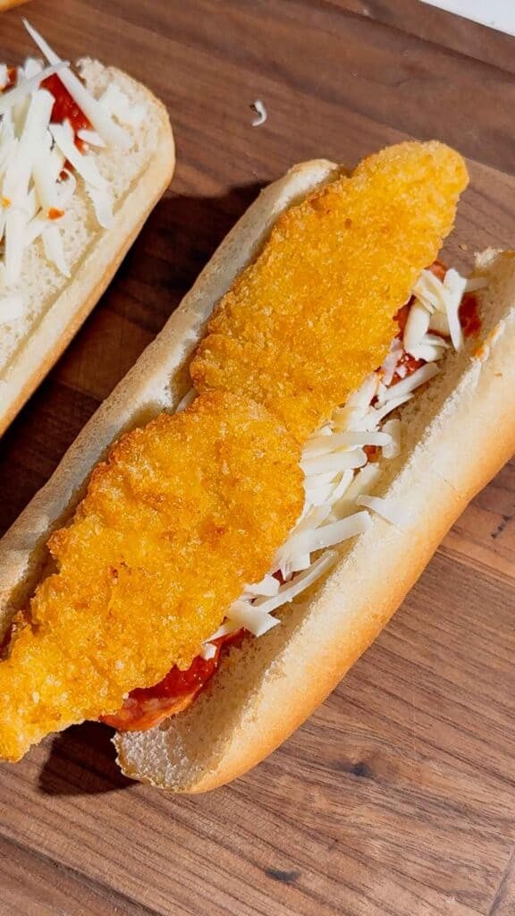hot dog buns on top of shredded mozzarella cheese in a hot dog bun