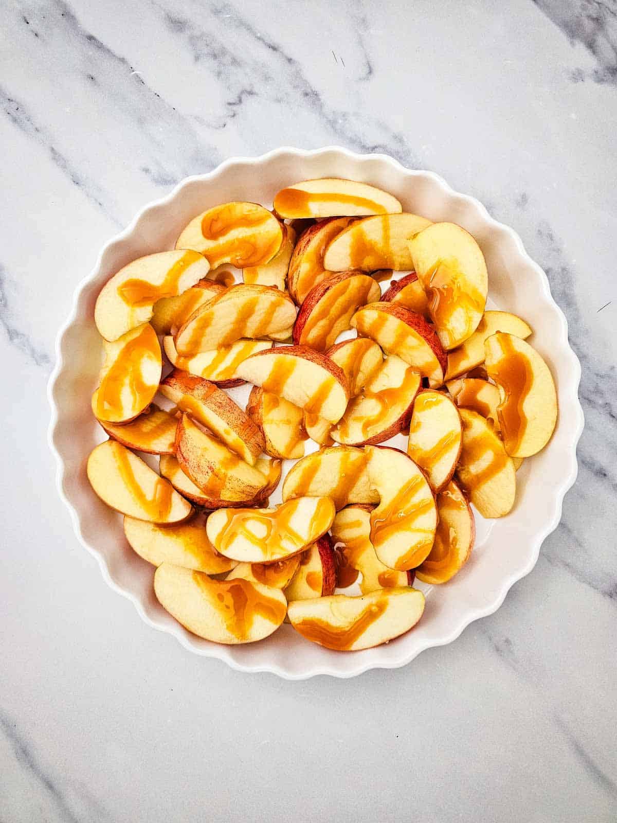 caramel sauce on top of apple slices in a serving dish