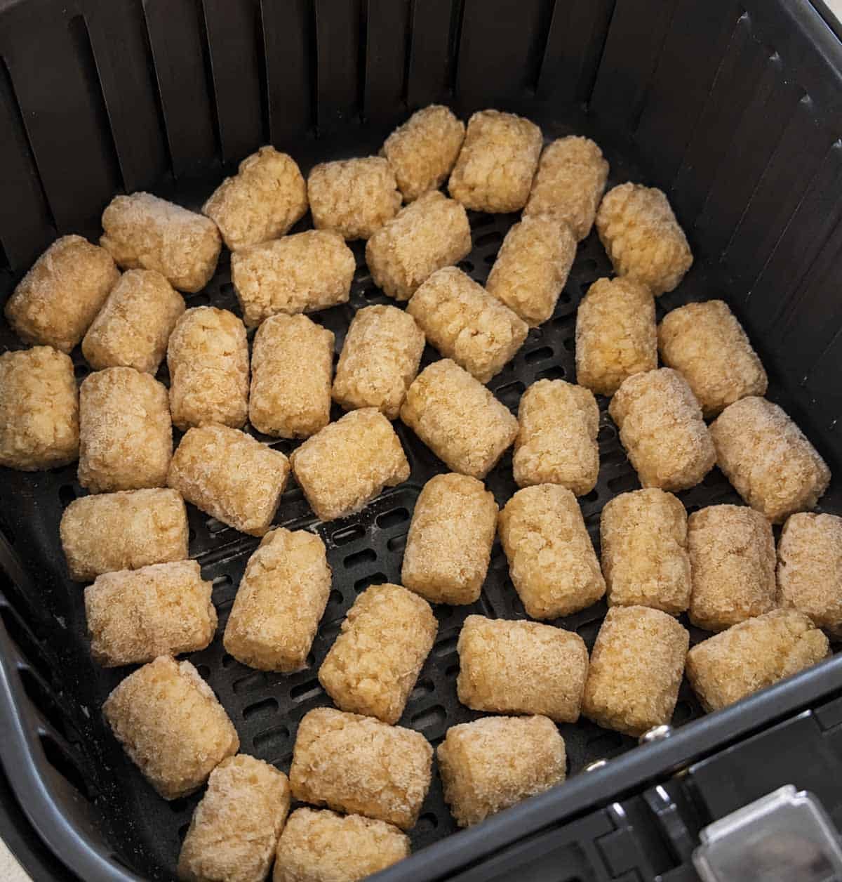 frozen tater tots in an air fryer basket