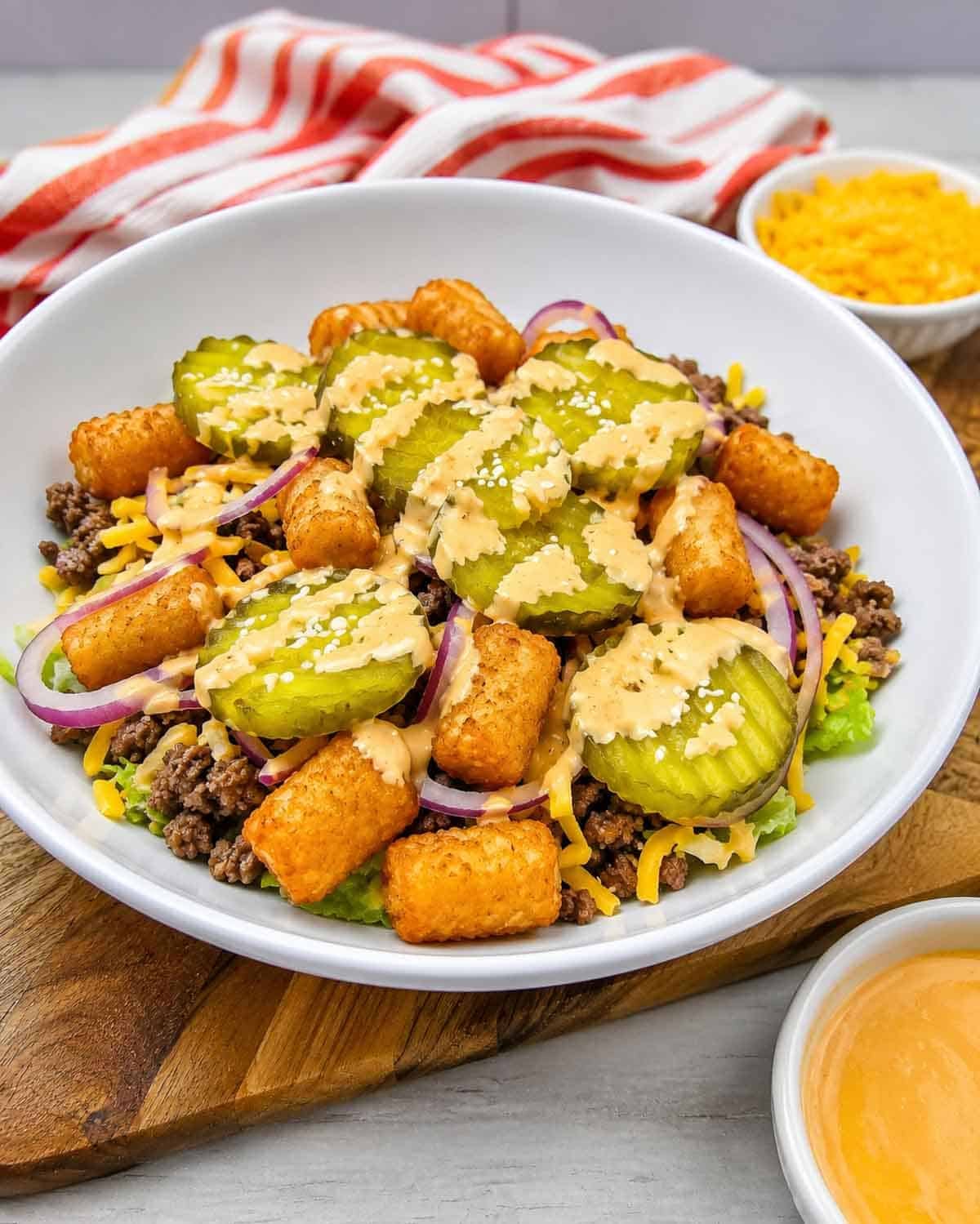 Craving all the flavors of your favorite fast food burger without the bun? This Big Mac Bowl is loaded with seasoned ground beef, crispy tater tots, shredded lettuce, cheddar cheese, red onion, pickles, sesame seeds, and a creamy special sauce for an easy meal the whole family will love. If you're looking for Big Mac Bowl Recipe, Burger Bowl Recipe, Cheeseburger Bowl, Low Carb Big Mac Bowl, Big Mac Salad Bowl, Ground Beef Dinner Ideas, Easy Ground Beef Recipes, Big Mac Casserole Inspiration, Burger Salad Recipe, or Quick Weeknight Dinners, this simple recipe is packed with classic burger flavor, comes together in under 20 minutes, and is perfect for busy nights, meal prep, or an easy comfort food dinner everyone will request again and again.