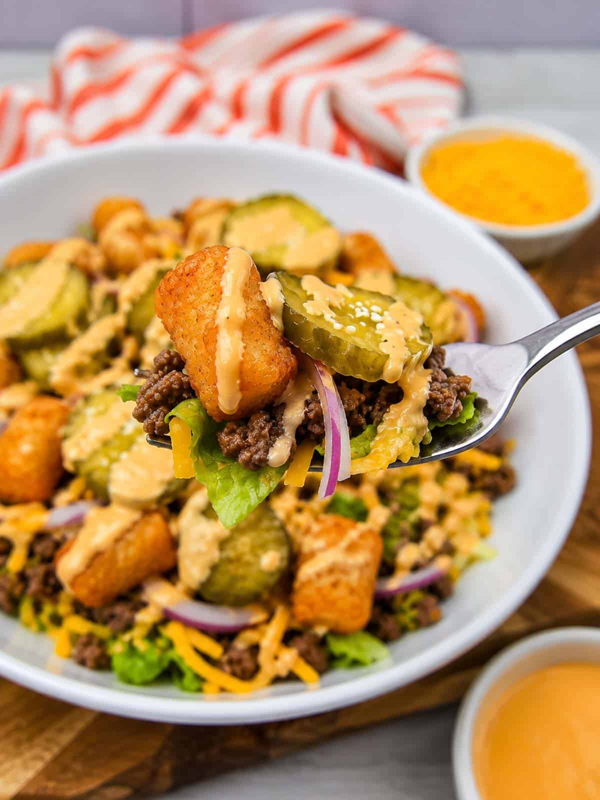 Craving all the flavors of your favorite fast food burger without the bun? This Big Mac Bowl is loaded with seasoned ground beef, crispy tater tots, shredded lettuce, cheddar cheese, red onion, pickles, sesame seeds, and a creamy special sauce for an easy meal the whole family will love. If you're looking for Big Mac Bowl Recipe, Burger Bowl Recipe, Cheeseburger Bowl, Low Carb Big Mac Bowl, Big Mac Salad Bowl, Ground Beef Dinner Ideas, Easy Ground Beef Recipes, Big Mac Casserole Inspiration, Burger Salad Recipe, or Quick Weeknight Dinners, this simple recipe is packed with classic burger flavor, comes together in under 20 minutes, and is perfect for busy nights, meal prep, or an easy comfort food dinner everyone will request again and again.