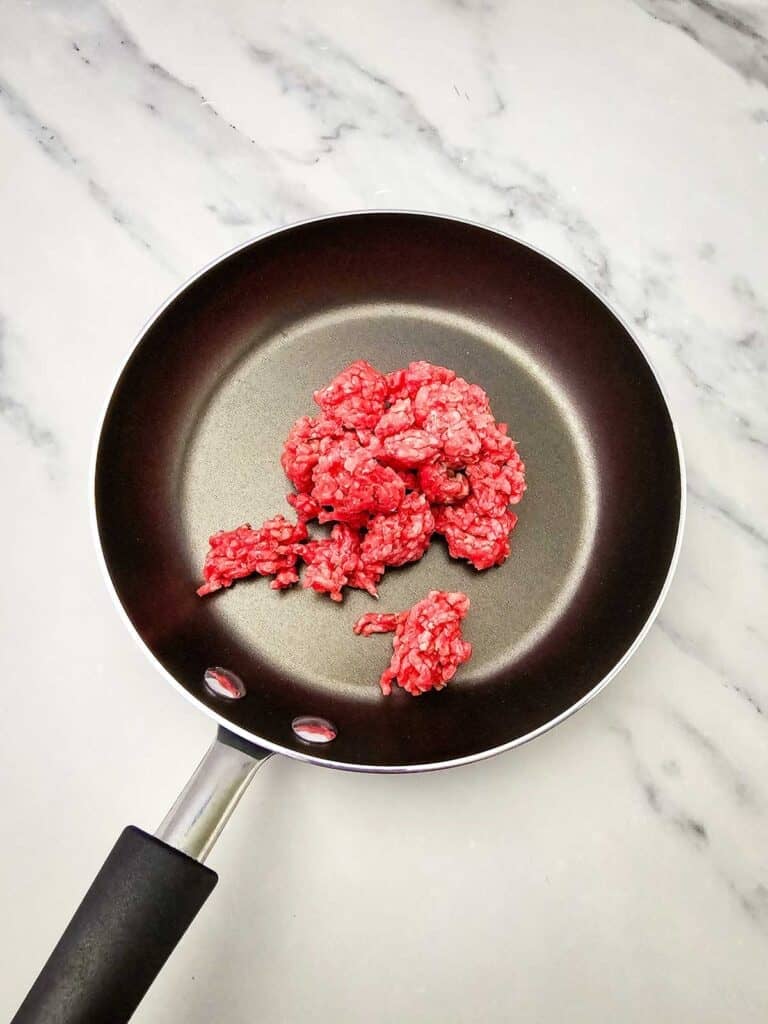 raw ground beef in a skillet