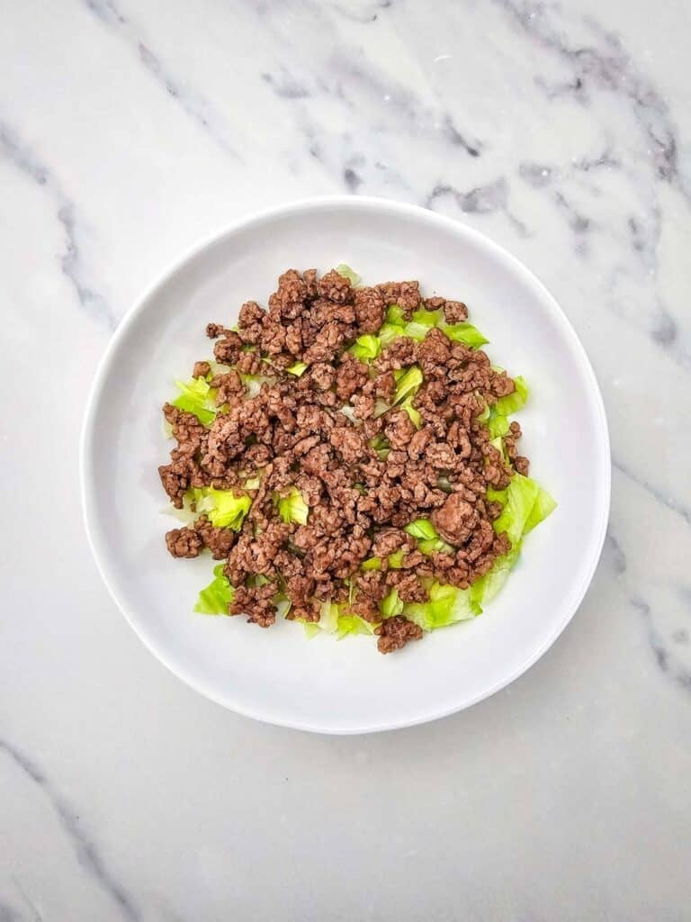 cooked ground beef and lettuce in a bowl