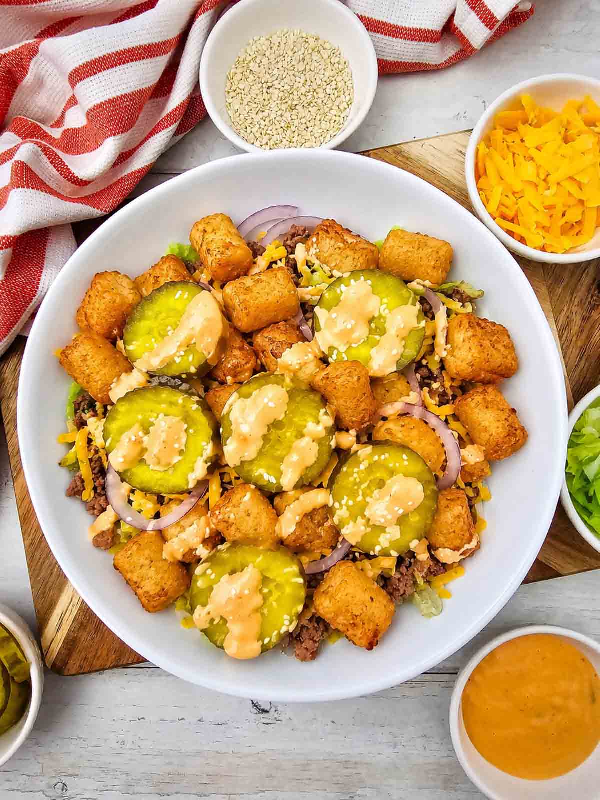 Craving all the flavors of your favorite fast food burger without the bun? This Big Mac Bowl is loaded with seasoned ground beef, crispy tater tots, shredded lettuce, cheddar cheese, red onion, pickles, sesame seeds, and a creamy special sauce for an easy meal the whole family will love. If you're looking for Big Mac Bowl Recipe, Burger Bowl Recipe, Cheeseburger Bowl, Low Carb Big Mac Bowl, Big Mac Salad Bowl, Ground Beef Dinner Ideas, Easy Ground Beef Recipes, Big Mac Casserole Inspiration, Burger Salad Recipe, or Quick Weeknight Dinners, this simple recipe is packed with classic burger flavor, comes together in under 20 minutes, and is perfect for busy nights, meal prep, or an easy comfort food dinner everyone will request again and again.