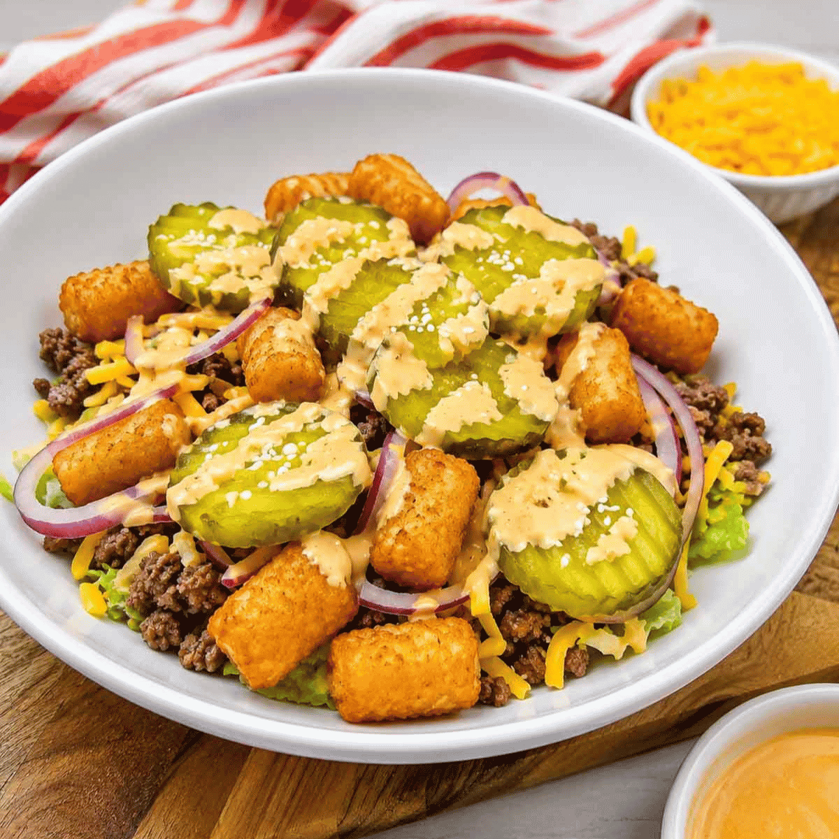 Craving all the flavors of your favorite fast food burger without the bun? This Big Mac Bowl is loaded with seasoned ground beef, crispy tater tots, shredded lettuce, cheddar cheese, red onion, pickles, sesame seeds, and a creamy special sauce for an easy meal the whole family will love. If you're looking for Big Mac Bowl Recipe, Burger Bowl Recipe, Cheeseburger Bowl, Low Carb Big Mac Bowl, Big Mac Salad Bowl, Ground Beef Dinner Ideas, Easy Ground Beef Recipes, Big Mac Casserole Inspiration, Burger Salad Recipe, or Quick Weeknight Dinners, this simple recipe is packed with classic burger flavor, comes together in under 20 minutes, and is perfect for busy nights, meal prep, or an easy comfort food dinner everyone will request again and again.