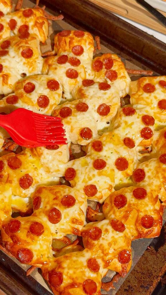 Looking for an easy pizza appetizer everyone will love? These Biscuit Pizza Bites are the perfect bite-sized snack made with refrigerated biscuit dough, mozzarella cheese, mini pepperoni, garlic butter, and fresh parsley. They're crispy, cheesy, buttery, and ready in under 30 minutes, making them ideal for easy appetizer recipes, game day snacks, party food ideas, after school snacks, quick dinner ideas, kid friendly meals, and finger food recipes. Serve them with pizza sauce, ranch, or garlic dipping sauce for the ultimate crowd-pleasing treat. Whether you're planning a family movie night, holiday party, football gathering, or need a simple weeknight recipe, these homemade pizza bites are guaranteed to disappear fast. Save this easy pizza snack recipe for your next party, potluck, or busy weeknight dinner!