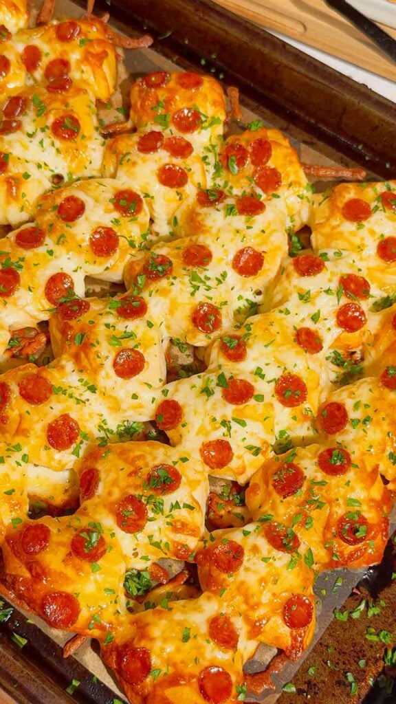Looking for an easy pizza appetizer everyone will love? These Biscuit Pizza Bites are the perfect bite-sized snack made with refrigerated biscuit dough, mozzarella cheese, mini pepperoni, garlic butter, and fresh parsley. They're crispy, cheesy, buttery, and ready in under 30 minutes, making them ideal for easy appetizer recipes, game day snacks, party food ideas, after school snacks, quick dinner ideas, kid friendly meals, and finger food recipes. Serve them with pizza sauce, ranch, or garlic dipping sauce for the ultimate crowd-pleasing treat. Whether you're planning a family movie night, holiday party, football gathering, or need a simple weeknight recipe, these homemade pizza bites are guaranteed to disappear fast. Save this easy pizza snack recipe for your next party, potluck, or busy weeknight dinner!