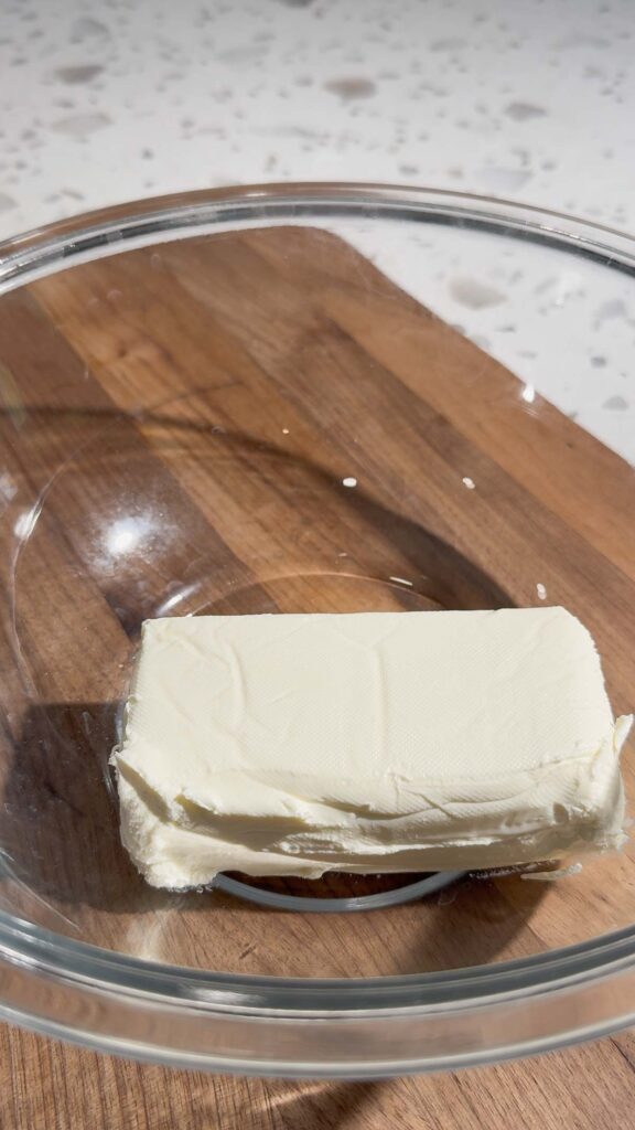 cream cheese in a glass mixing bowl