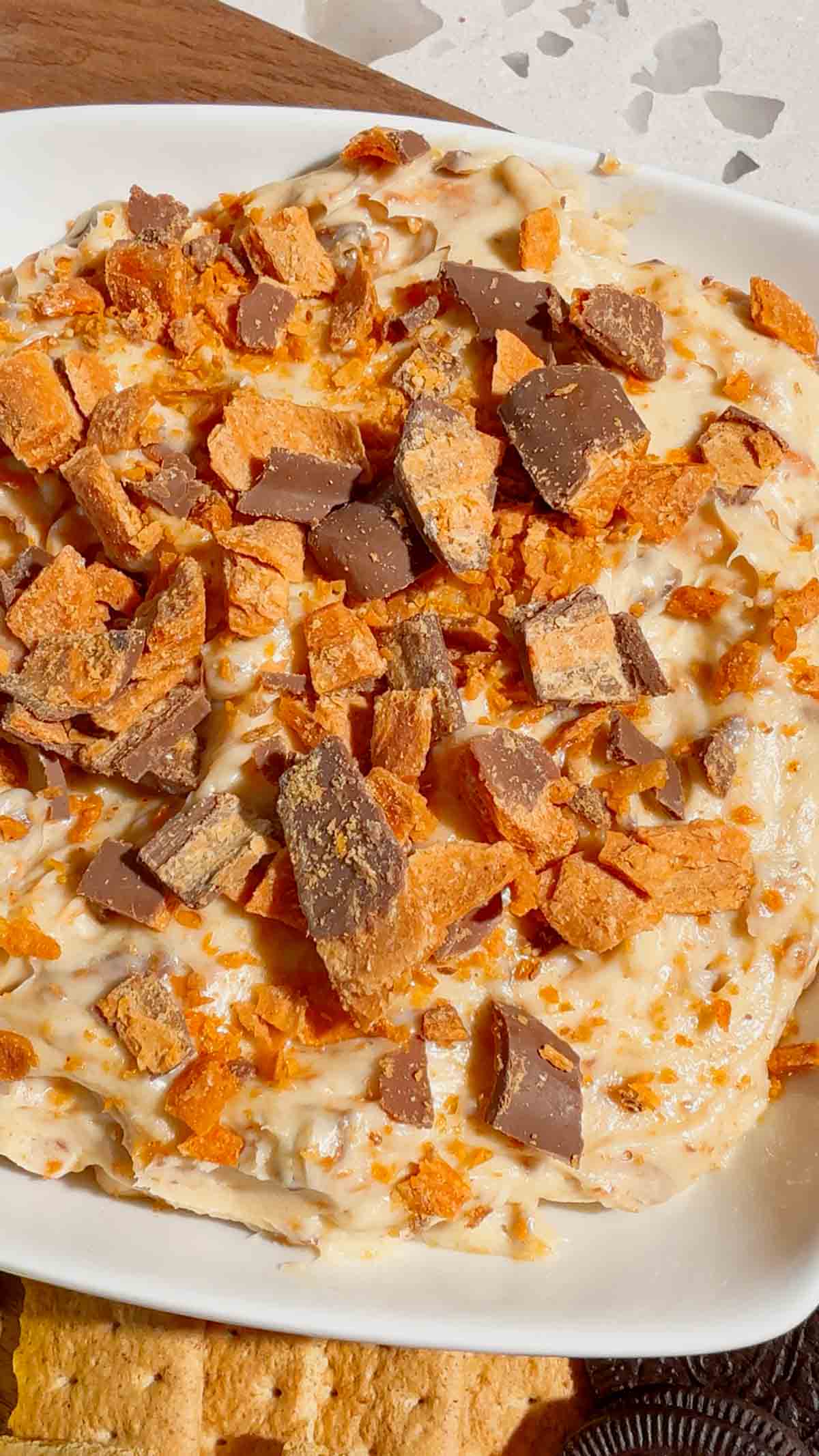 If you're looking for the ultimate no bake dessert, this Butterfinger Dip is about to become your new favorite sweet treat. Made with cream cheese, butter, brown sugar, vanilla, and plenty of chopped Butterfinger candy bars, this creamy dessert dip is perfect for parties, game day, holidays, movie nights, and potlucks. Serve it with graham crackers, vanilla wafers, pretzels, apple slices, strawberries, or cookies for an easy crowd-pleasing snack. This easy dessert dip recipe takes just 10 minutes to make with no baking required, making it ideal for last-minute entertaining. Save this Butterfinger Dip recipe for your favorite candy dessert, no bake desserts, party food ideas, easy dessert recipes, and delicious dessert dips everyone will love.