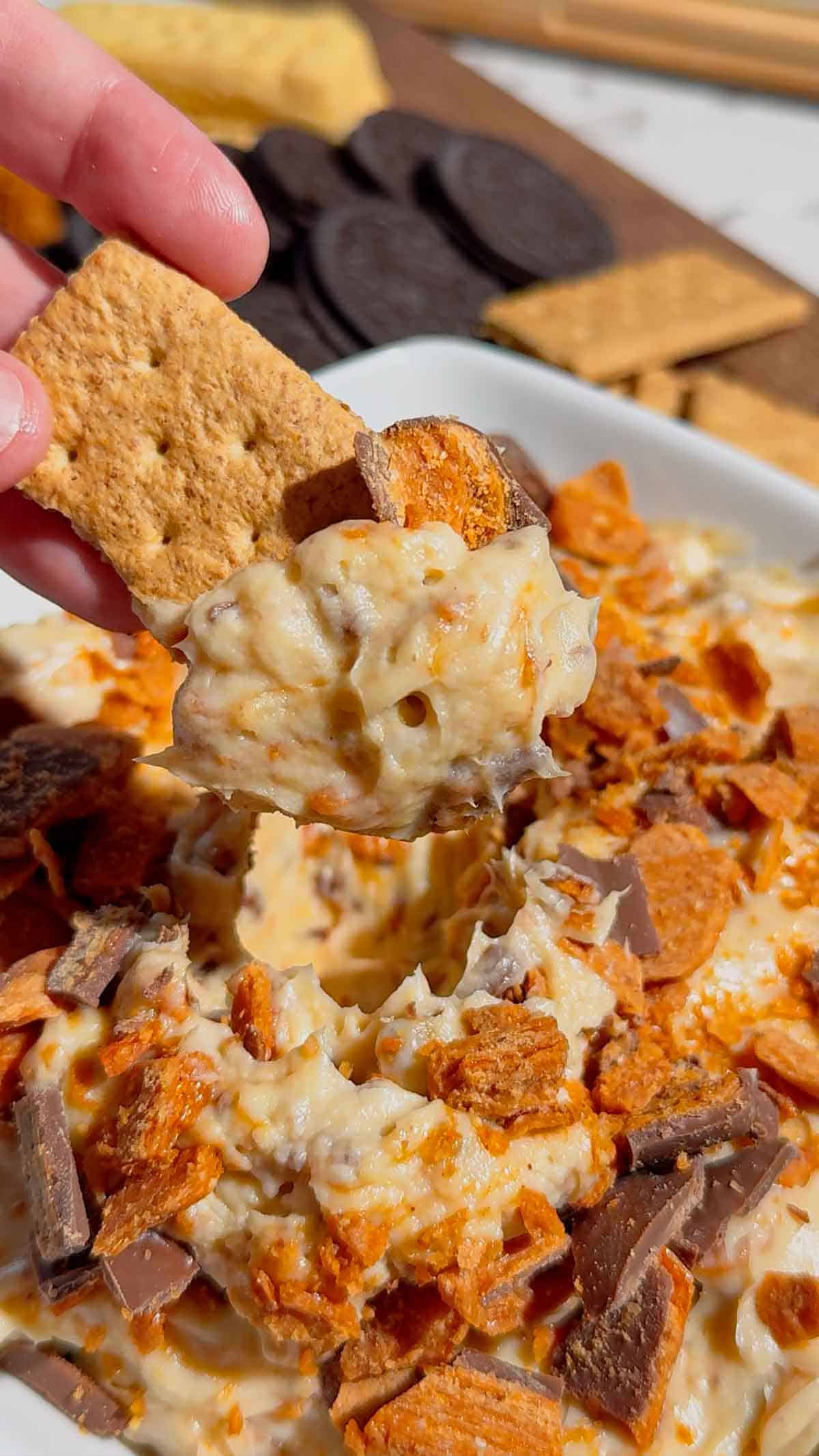 If you're looking for the ultimate no bake dessert, this Butterfinger Dip is about to become your new favorite sweet treat. Made with cream cheese, butter, brown sugar, vanilla, and plenty of chopped Butterfinger candy bars, this creamy dessert dip is perfect for parties, game day, holidays, movie nights, and potlucks. Serve it with graham crackers, vanilla wafers, pretzels, apple slices, strawberries, or cookies for an easy crowd-pleasing snack. This easy dessert dip recipe takes just 10 minutes to make with no baking required, making it ideal for last-minute entertaining. Save this Butterfinger Dip recipe for your favorite candy dessert, no bake desserts, party food ideas, easy dessert recipes, and delicious dessert dips everyone will love.