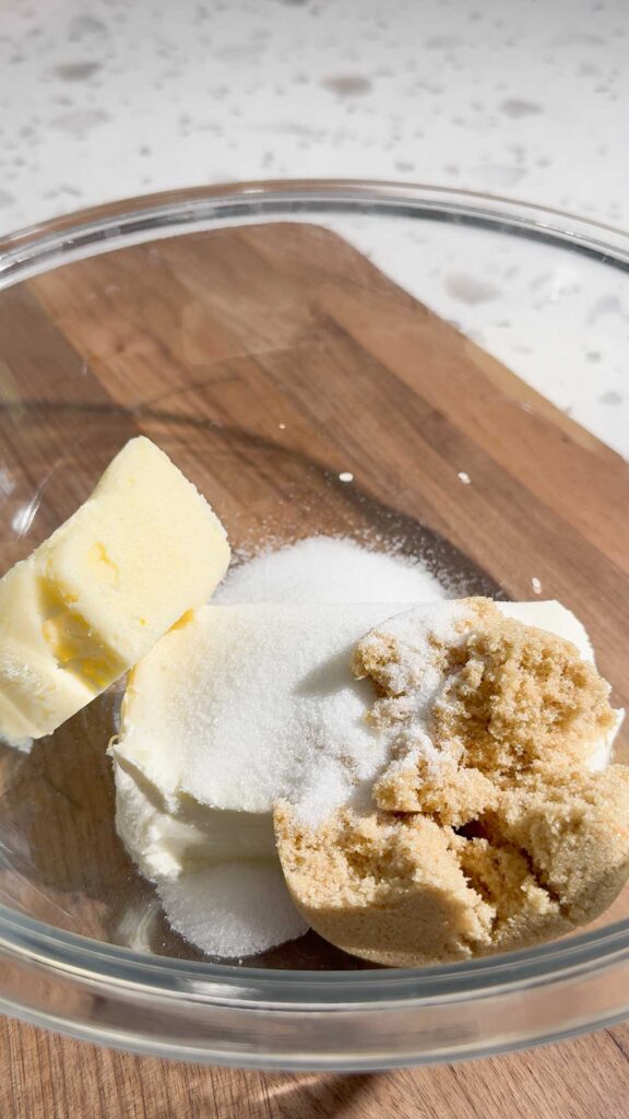 brown sugar, white sugar, cream cheese and butter in a glass bowl
