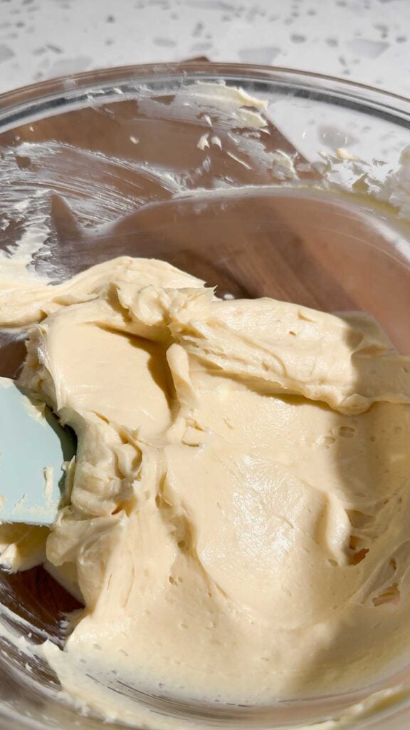 scraping butterfinger dip off the sides of a mixing bowl with a rubber spatula