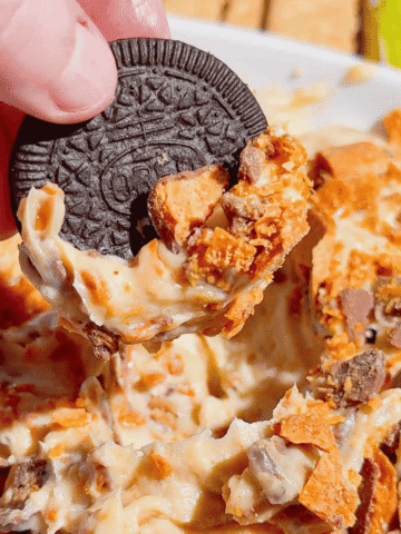 If you're looking for the ultimate no bake dessert, this Butterfinger Dip is about to become your new favorite sweet treat. Made with cream cheese, butter, brown sugar, vanilla, and plenty of chopped Butterfinger candy bars, this creamy dessert dip is perfect for parties, game day, holidays, movie nights, and potlucks. Serve it with graham crackers, vanilla wafers, pretzels, apple slices, strawberries, or cookies for an easy crowd-pleasing snack. This easy dessert dip recipe takes just 10 minutes to make with no baking required, making it ideal for last-minute entertaining. Save this Butterfinger Dip recipe for your favorite candy dessert, no bake desserts, party food ideas, easy dessert recipes, and delicious dessert dips everyone will love.