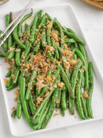 Looking for the best Chinese Green Beans recipe? These easy Asian Green Beans are crisp-tender, packed with garlic, ginger, shallots, and a savory touch of mirin for an irresistible restaurant-style side dish. If you've been searching for Chinese Green Bean Recipes, Garlic Green Beans, Stir Fry Green Beans, Green Bean Side Dish, Easy Vegetable Side Dishes, Healthy Green Bean Recipes, Asian Side Dishes, or How to Cook Fresh Green Beans, this simple recipe is a must-try. Perfect for busy weeknights, holiday dinners, or serving with your favorite chicken, beef, pork, or rice dishes, these flavorful sesame green beans come together in under 30 minutes and taste even better than takeout. Save this easy green bean recipe for your next family meal!