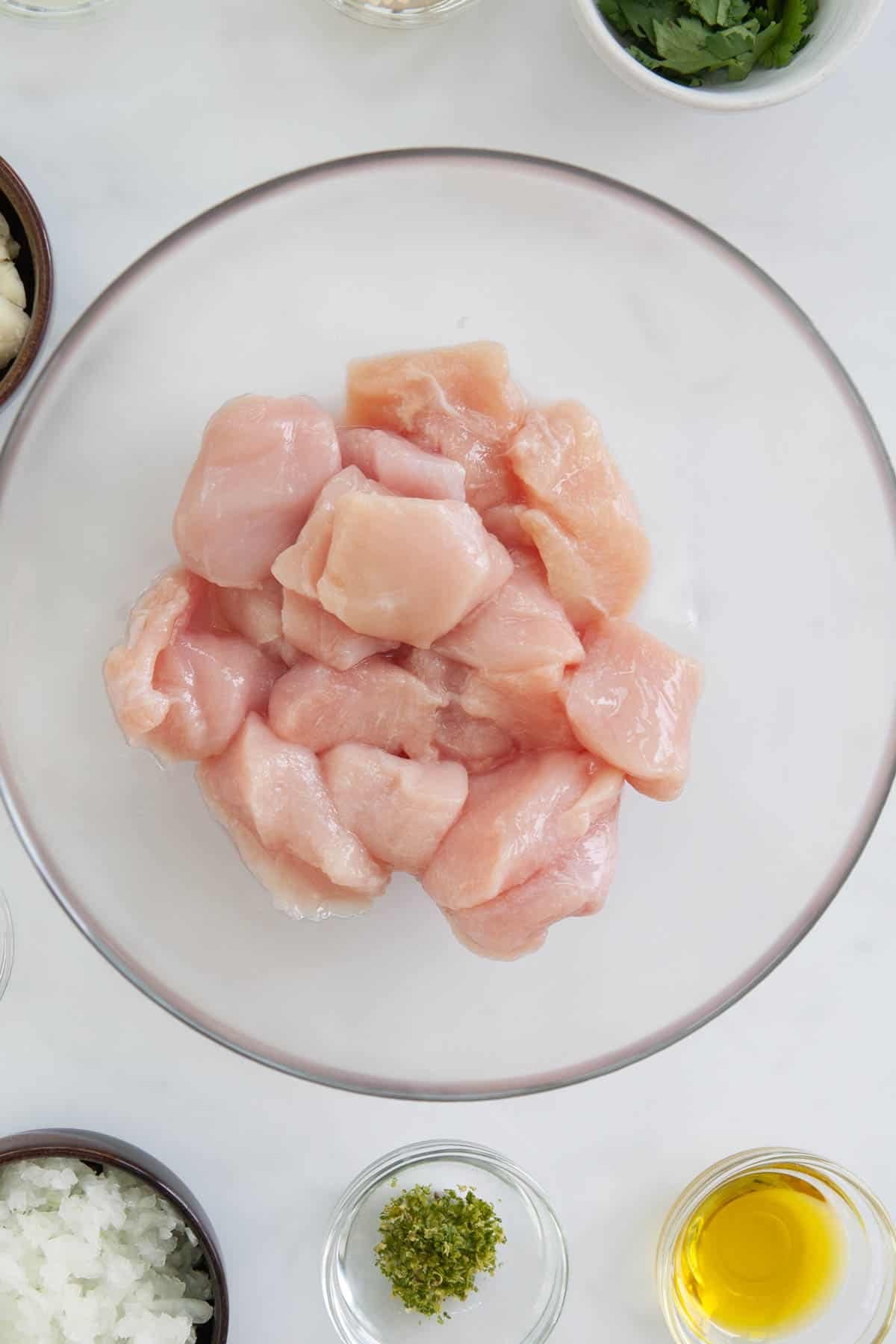 raw chicken breast chunks in a glass bowl