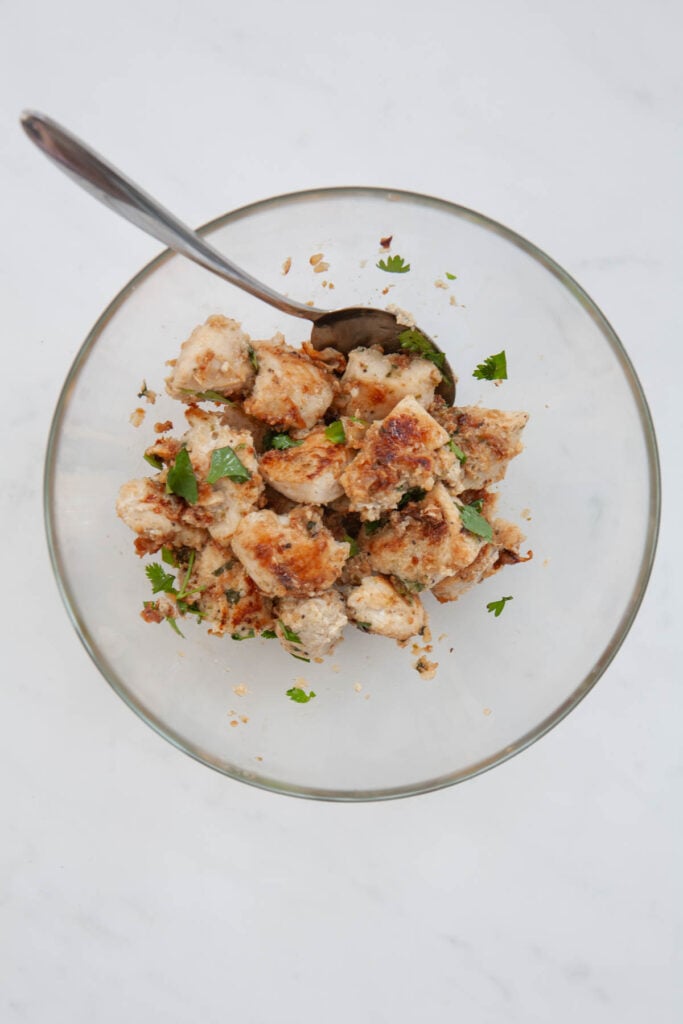 tossing cooked chicken breast chunks with chopped cilantro