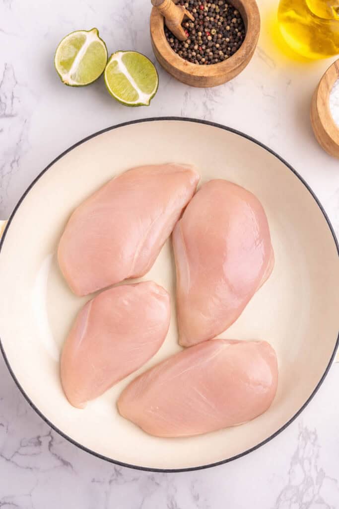 raw chicken breasts in a skillet