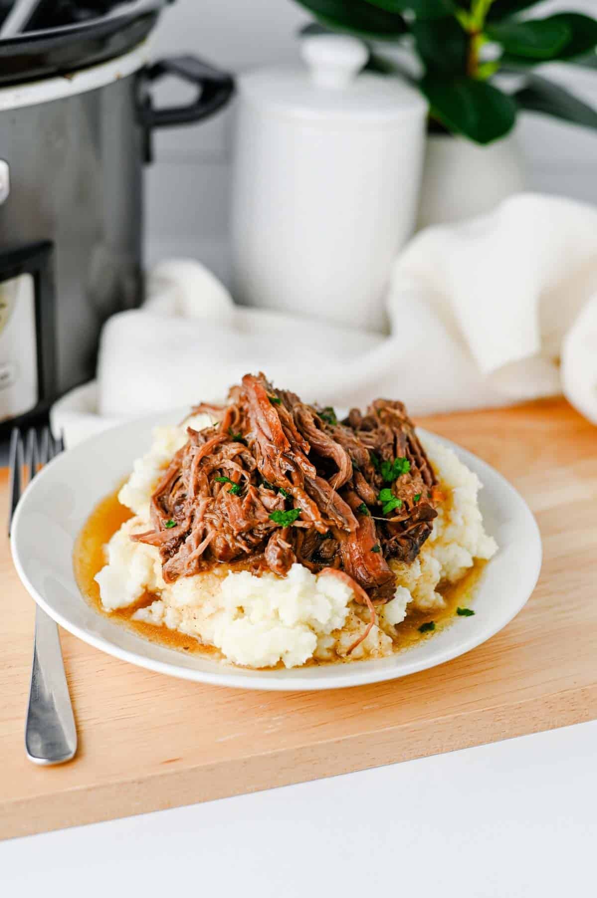 Looking for the best Crock Pot Mississippi Pot Roast recipe? This easy slow cooker Mississippi pot roast is made with chuck roast, ranch seasoning, au jus gravy mix, butter, and pepperoncini peppers for a rich, tender, melt-in-your-mouth dinner the whole family will love. Perfect for easy crock pot dinners, slow cooker beef recipes, comfort food recipes, Sunday dinner ideas, and busy weeknight meals, this recipe requires only 10 minutes of prep before the crock pot does all the work. Serve it over creamy mashed potatoes, rice, or egg noodles for a hearty meal that's packed with flavor. Save this simple Mississippi pot roast recipe for your next cozy family dinner or meal prep favorite!