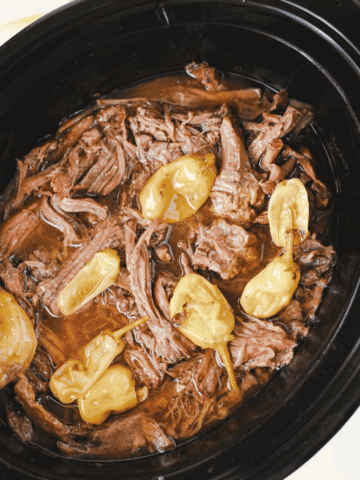 Looking for the best Crock Pot Mississippi Pot Roast recipe? This easy slow cooker Mississippi pot roast is made with chuck roast, ranch seasoning, au jus gravy mix, butter, and pepperoncini peppers for a rich, tender, melt-in-your-mouth dinner the whole family will love. Perfect for easy crock pot dinners, slow cooker beef recipes, comfort food recipes, Sunday dinner ideas, and busy weeknight meals, this recipe requires only 10 minutes of prep before the crock pot does all the work. Serve it over creamy mashed potatoes, rice, or egg noodles for a hearty meal that's packed with flavor. Save this simple Mississippi pot roast recipe for your next cozy family dinner or meal prep favorite!