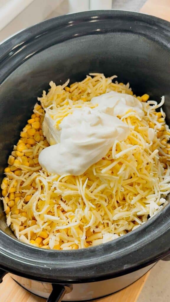 sour cream, shredded cheese, cream cheese and frozen corn in a crock pot