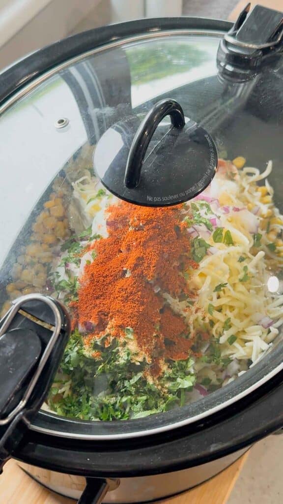 street corn dip ingredients in a crock pot with the lid on