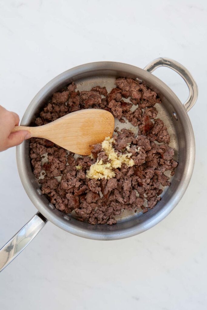 stirring garlic and ginger in with cooked ground beef