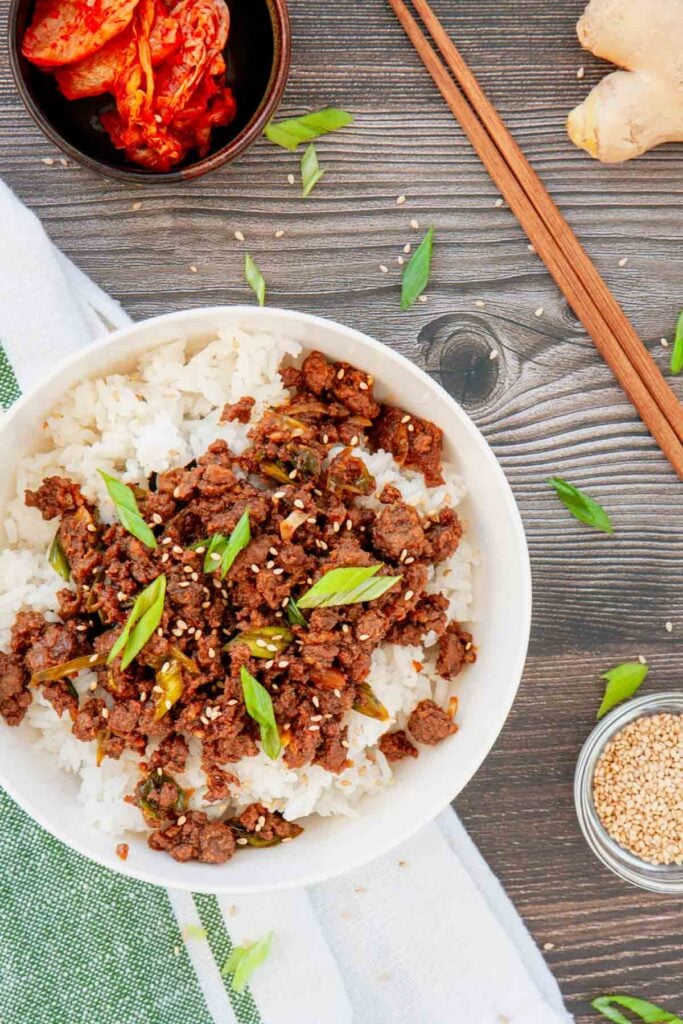 Craving a fast dinner that's packed with flavor? These Korean Ground Beef Bowls are the ultimate weeknight meal, made with tender ground beef coated in a sweet, savory, and slightly spicy Korean-inspired sauce with soy sauce, brown sugar, garlic, ginger, sesame oil, and gochujang. Served over fluffy rice and topped with green onions and sesame seeds, this easy Ground Beef Bowl is ready in just 15 minutes. Perfect for Easy Ground Beef Recipes, Korean Beef Rice Bowls, Ground Beef Dinner Ideas, Quick Family Meals, Asian Inspired Recipes, Weeknight Dinner Recipes, Meal Prep Bowls, Rice Bowl Recipes, Ground Beef and Rice, and Budget Friendly Dinners, this simple recipe is one you'll make again and again.