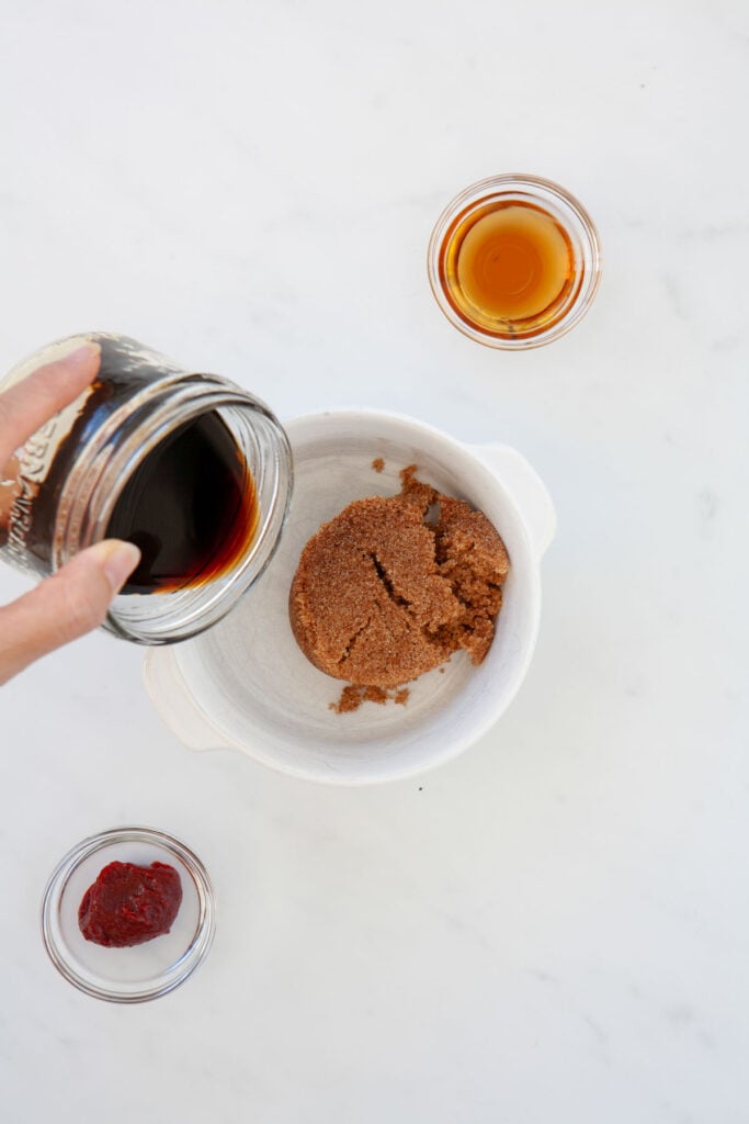 adding soy sauce to bowl with brown sugar