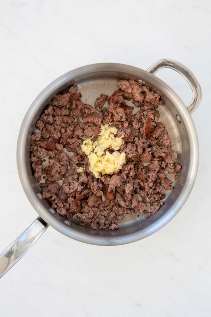 garlic and ginger added to skillet with cooked ground beef