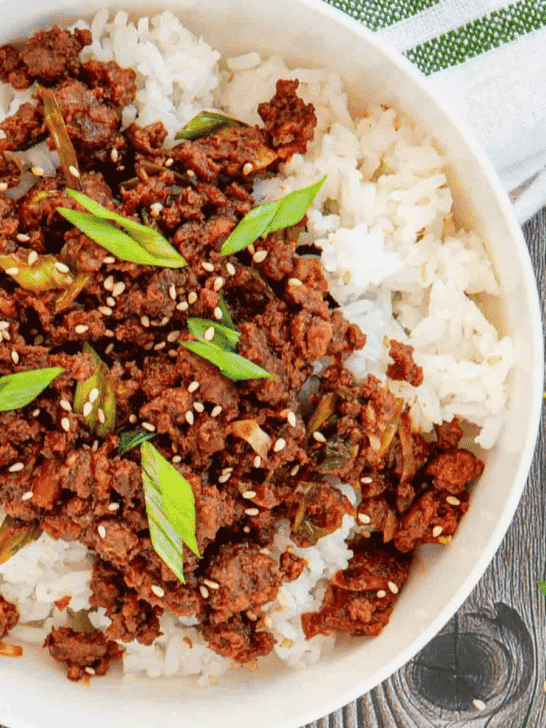 Craving a fast dinner that's packed with flavor? These Korean Ground Beef Bowls are the ultimate weeknight meal, made with tender ground beef coated in a sweet, savory, and slightly spicy Korean-inspired sauce with soy sauce, brown sugar, garlic, ginger, sesame oil, and gochujang. Served over fluffy rice and topped with green onions and sesame seeds, this easy Ground Beef Bowl is ready in just 15 minutes. Perfect for Easy Ground Beef Recipes, Korean Beef Rice Bowls, Ground Beef Dinner Ideas, Quick Family Meals, Asian Inspired Recipes, Weeknight Dinner Recipes, Meal Prep Bowls, Rice Bowl Recipes, Ground Beef and Rice, and Budget Friendly Dinners, this simple recipe is one you'll make again and again.