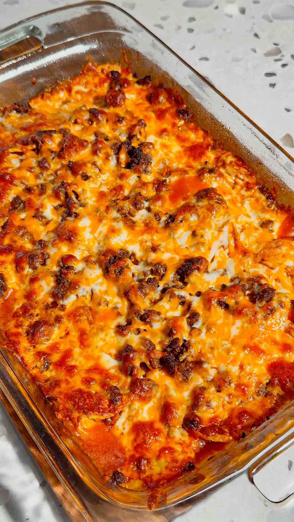Looking for an easy enchilada casserole the whole family will love? These Lazy Enchiladas are packed with seasoned ground beef, crunchy tortilla chips, rich red enchilada sauce, and loads of melted cheddar cheese for the ultimate comfort food dinner. This simple Mexican-inspired casserole skips the rolling but keeps all the bold flavor, making it perfect for busy weeknights, family dinners, potlucks, and meal prep. If you love easy ground beef recipes, cheesy casserole recipes, Tex-Mex dinners, quick family meals, tortilla chip casseroles, budget-friendly dinners, and simple comfort food recipes, this Lazy Enchiladas recipe is guaranteed to become a regular on your dinner menu. Save this easy enchilada casserole recipe for your next stress-free dinner!