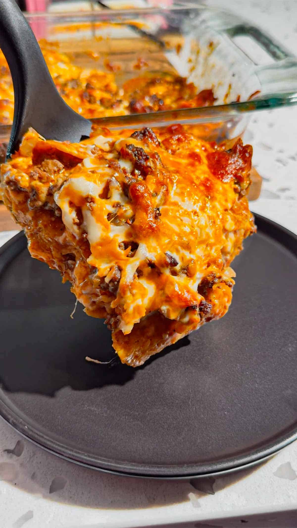 Looking for an easy enchilada casserole the whole family will love? These Lazy Enchiladas are packed with seasoned ground beef, crunchy tortilla chips, rich red enchilada sauce, and loads of melted cheddar cheese for the ultimate comfort food dinner. This simple Mexican-inspired casserole skips the rolling but keeps all the bold flavor, making it perfect for busy weeknights, family dinners, potlucks, and meal prep. If you love easy ground beef recipes, cheesy casserole recipes, Tex-Mex dinners, quick family meals, tortilla chip casseroles, budget-friendly dinners, and simple comfort food recipes, this Lazy Enchiladas recipe is guaranteed to become a regular on your dinner menu. Save this easy enchilada casserole recipe for your next stress-free dinner!