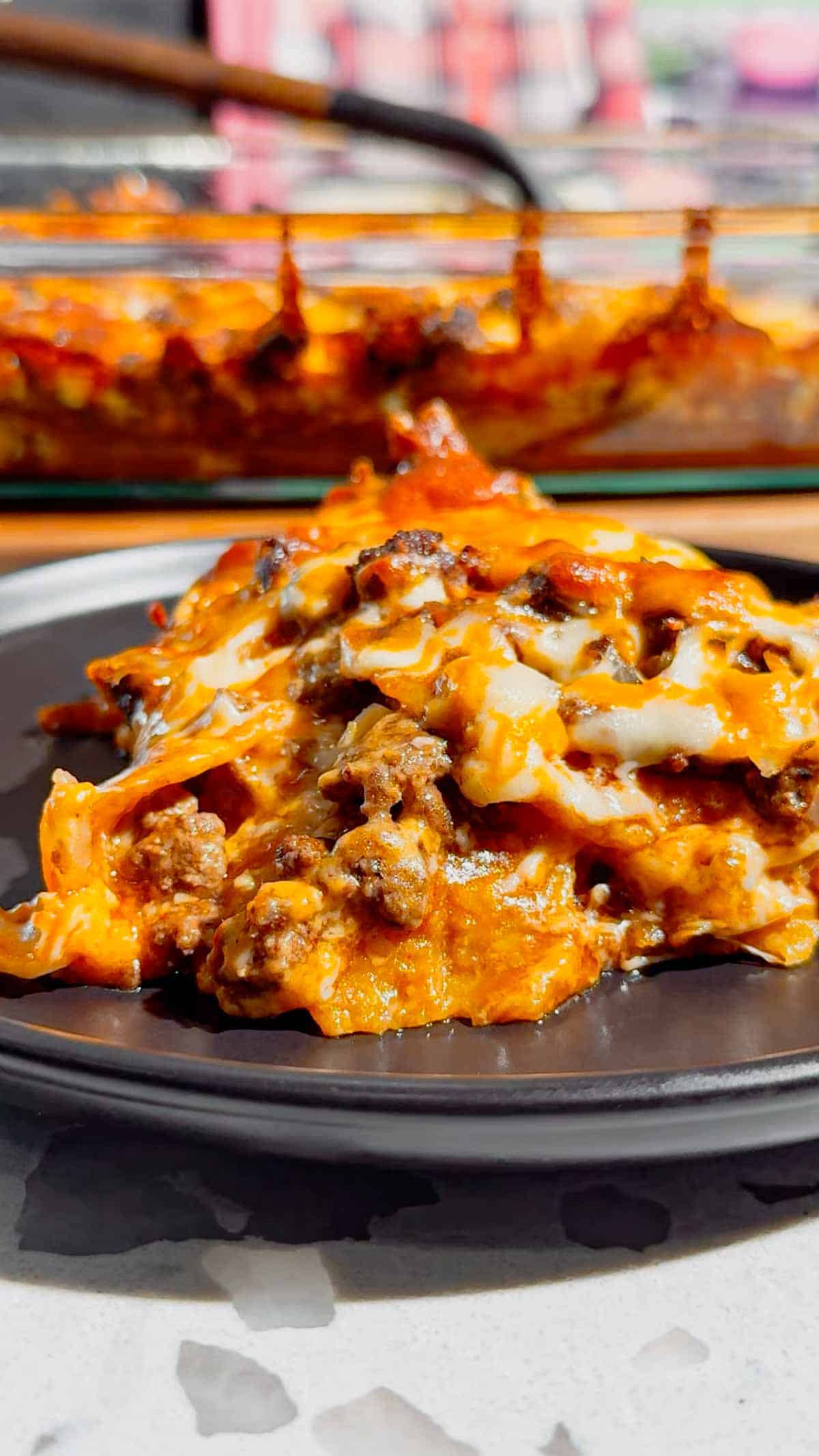 Looking for an easy enchilada casserole the whole family will love? These Lazy Enchiladas are packed with seasoned ground beef, crunchy tortilla chips, rich red enchilada sauce, and loads of melted cheddar cheese for the ultimate comfort food dinner. This simple Mexican-inspired casserole skips the rolling but keeps all the bold flavor, making it perfect for busy weeknights, family dinners, potlucks, and meal prep. If you love easy ground beef recipes, cheesy casserole recipes, Tex-Mex dinners, quick family meals, tortilla chip casseroles, budget-friendly dinners, and simple comfort food recipes, this Lazy Enchiladas recipe is guaranteed to become a regular on your dinner menu. Save this easy enchilada casserole recipe for your next stress-free dinner!