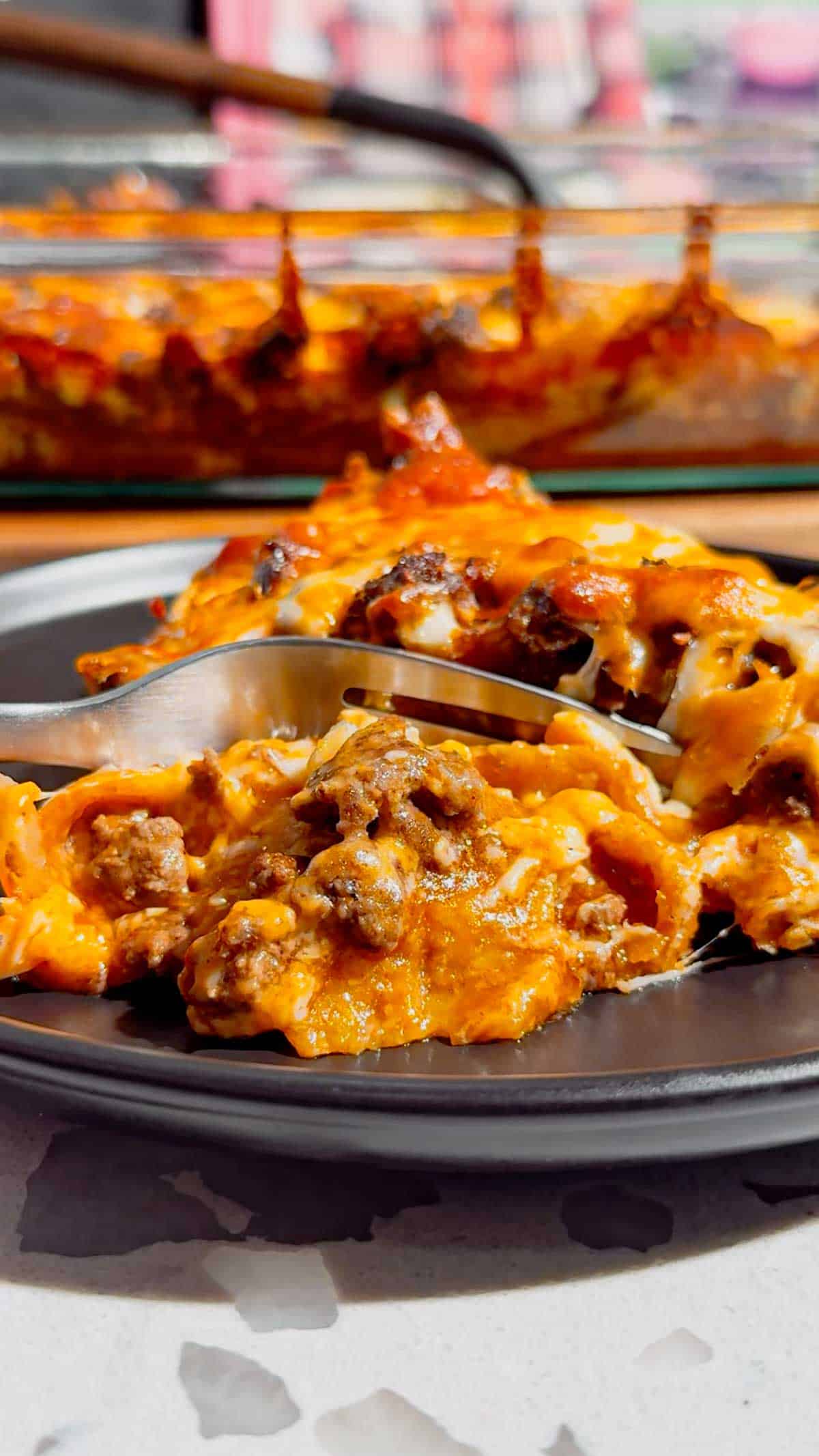 Looking for an easy enchilada casserole the whole family will love? These Lazy Enchiladas are packed with seasoned ground beef, crunchy tortilla chips, rich red enchilada sauce, and loads of melted cheddar cheese for the ultimate comfort food dinner. This simple Mexican-inspired casserole skips the rolling but keeps all the bold flavor, making it perfect for busy weeknights, family dinners, potlucks, and meal prep. If you love easy ground beef recipes, cheesy casserole recipes, Tex-Mex dinners, quick family meals, tortilla chip casseroles, budget-friendly dinners, and simple comfort food recipes, this Lazy Enchiladas recipe is guaranteed to become a regular on your dinner menu. Save this easy enchilada casserole recipe for your next stress-free dinner!