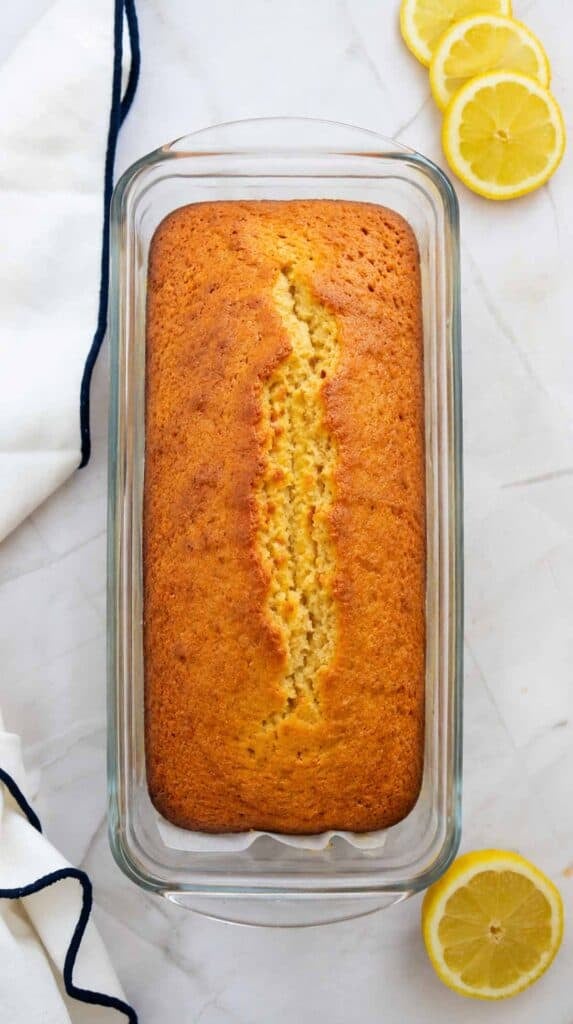 baked lemon loaf in a glass loaf pan