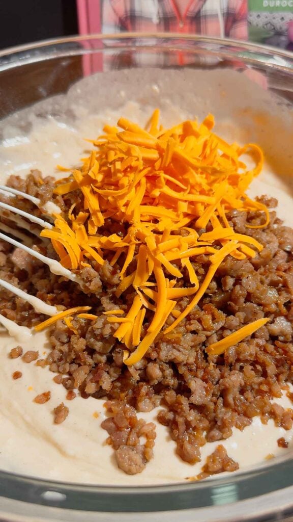 shredded cheddar and cooked sausge mixture added to bowl with pancake batter