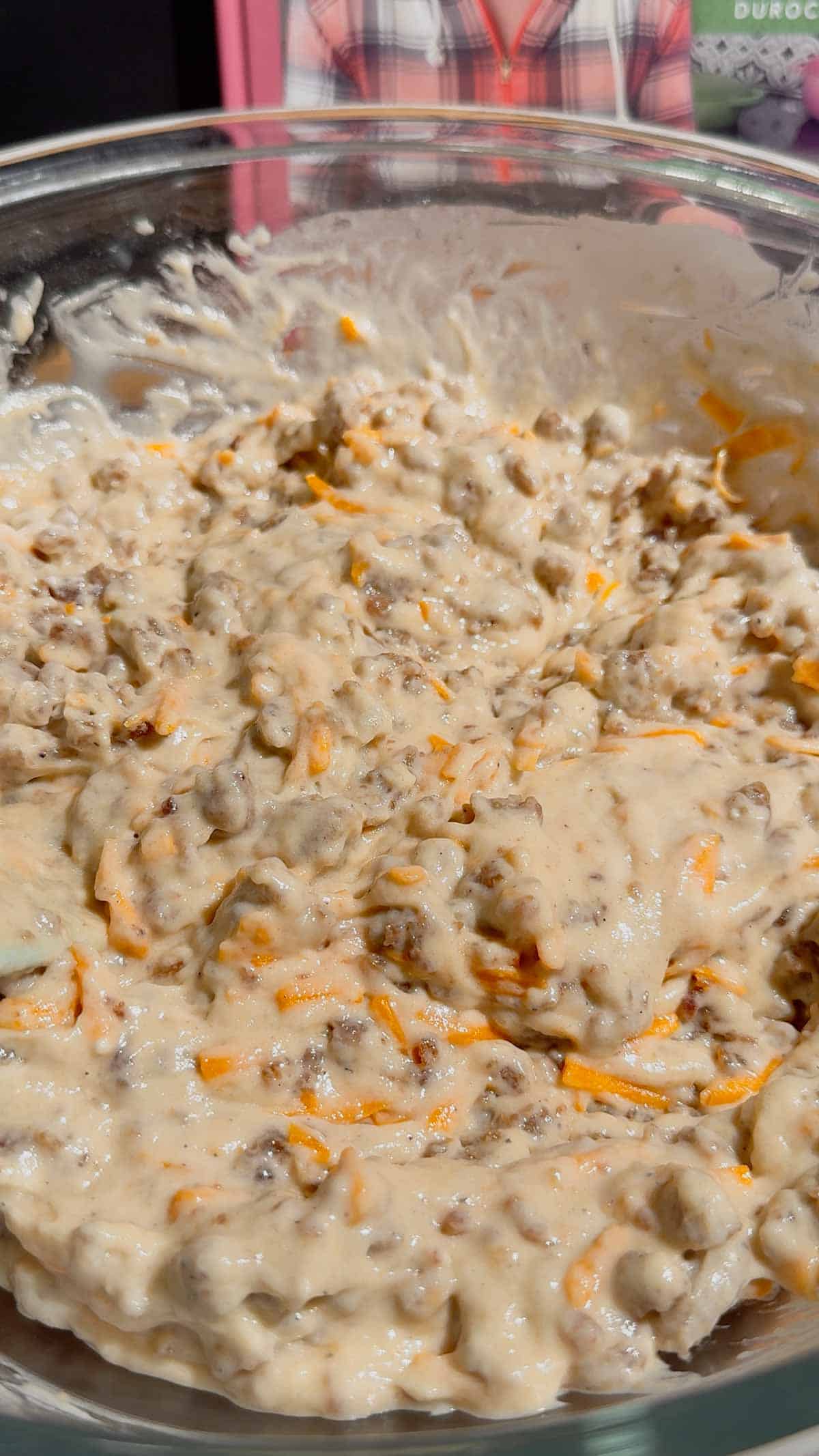 sausage and cheddar pancake batter in a glass bowl