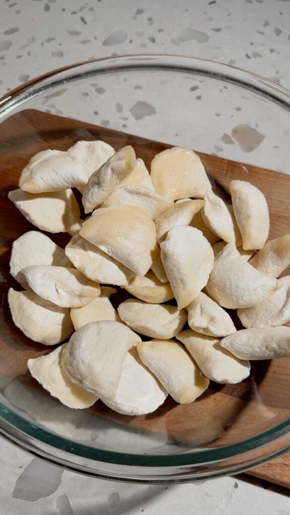 frozen pierogies in a glass mixing bowl